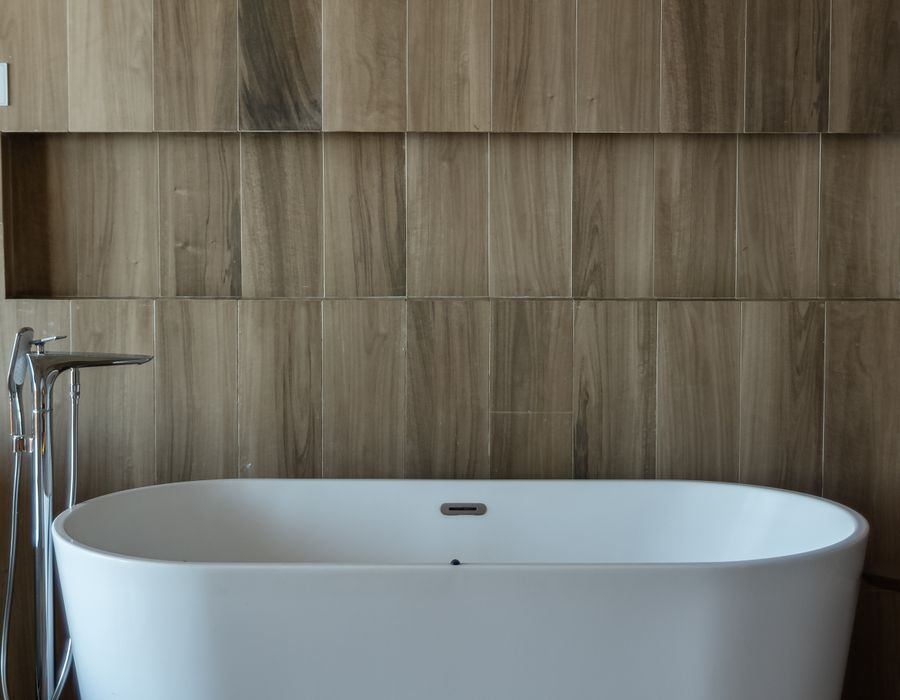 Weiße Badewanne in einem Bad mit Holzelementen